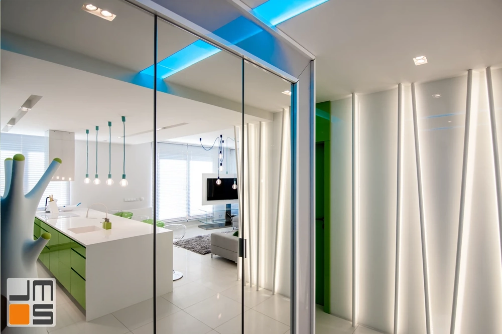 Nowoczesne wnętrze z kuchnią z wyspą, zielonymi szafkami i szklanymi przesuwnymi drzwiami – wykończenia wnętrz