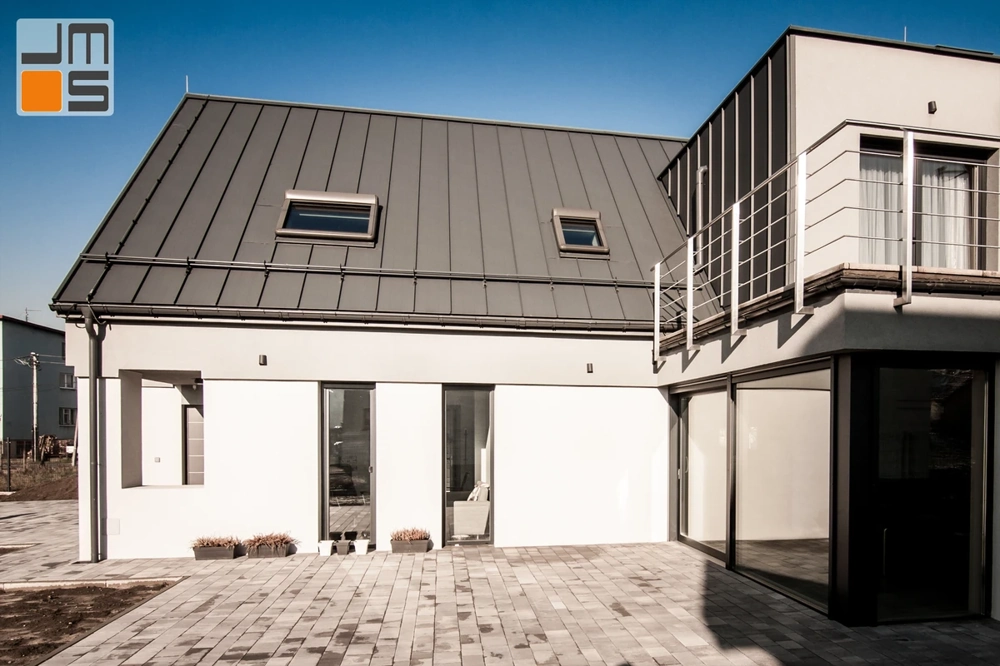 Nowoczesny dom jednorodzinny w stanie surowym zamkniętym z gotową elewacją, dużymi oknami i tarasem