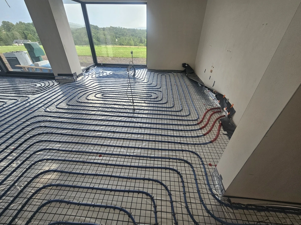 Instalacje hydrauliczne: instalacja ogrzewania podłogowego z pętlami rur na siatce zbrojeniowej