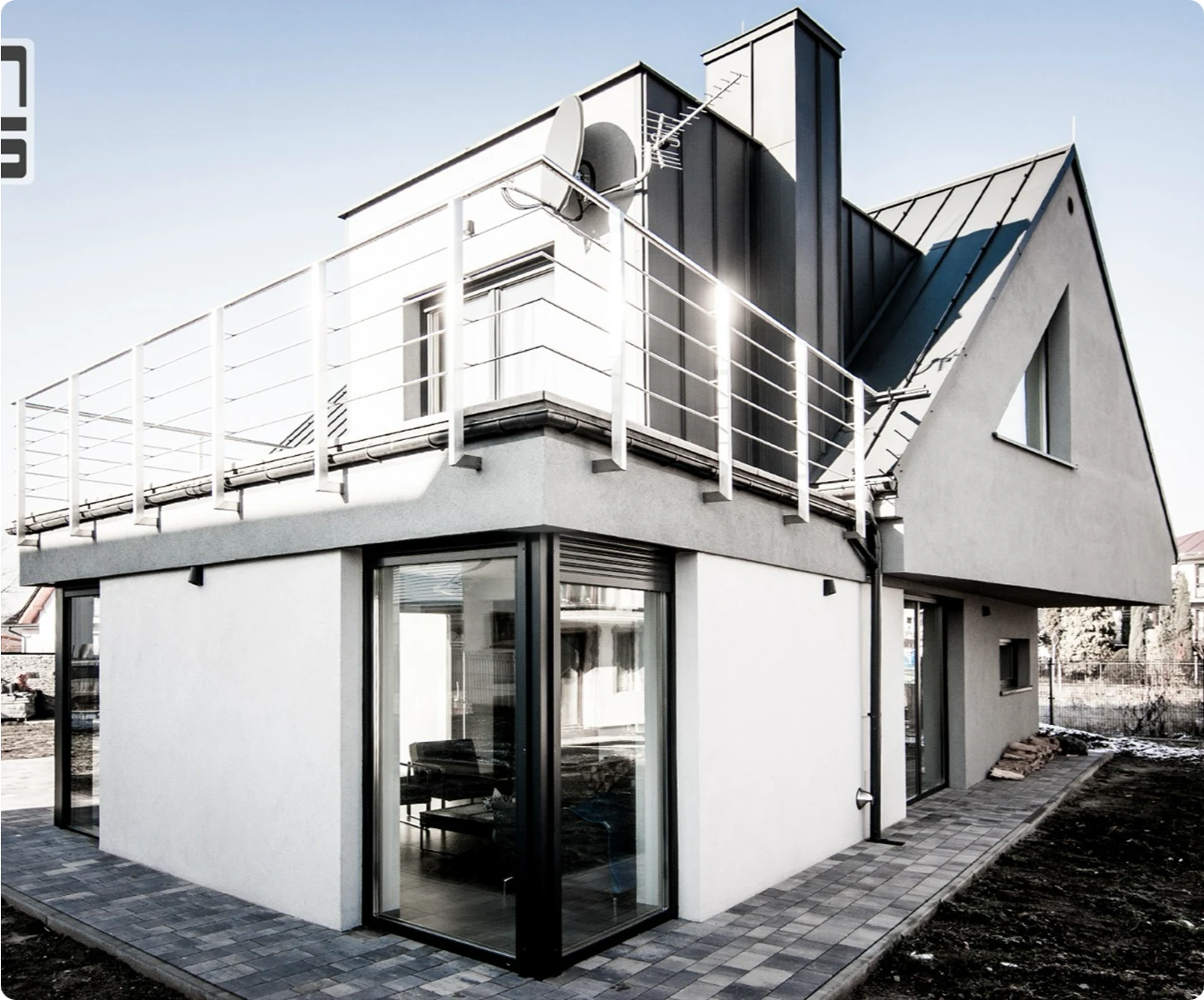 Nowoczesny jednorodzinny dom z elewacją, dużymi oknami i metalowym dachem w stanie surowym zamkniętym