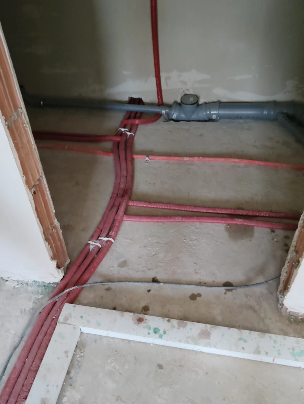 Instalacja hydrauliczna z rozprowadzonymi rurami na surowej posadzce przed wylewką