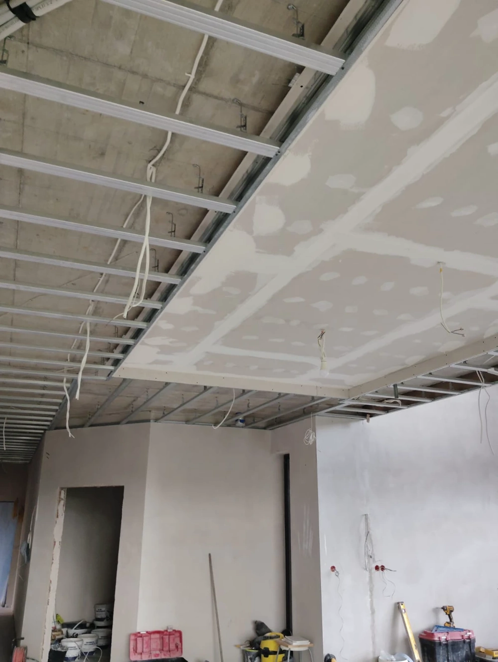 Montaż stelażu podwieszanego sufitu z fragmentem płyt gipsowo-kartonowych i przewodami elektrycznymi – Wykończenia wnętrz