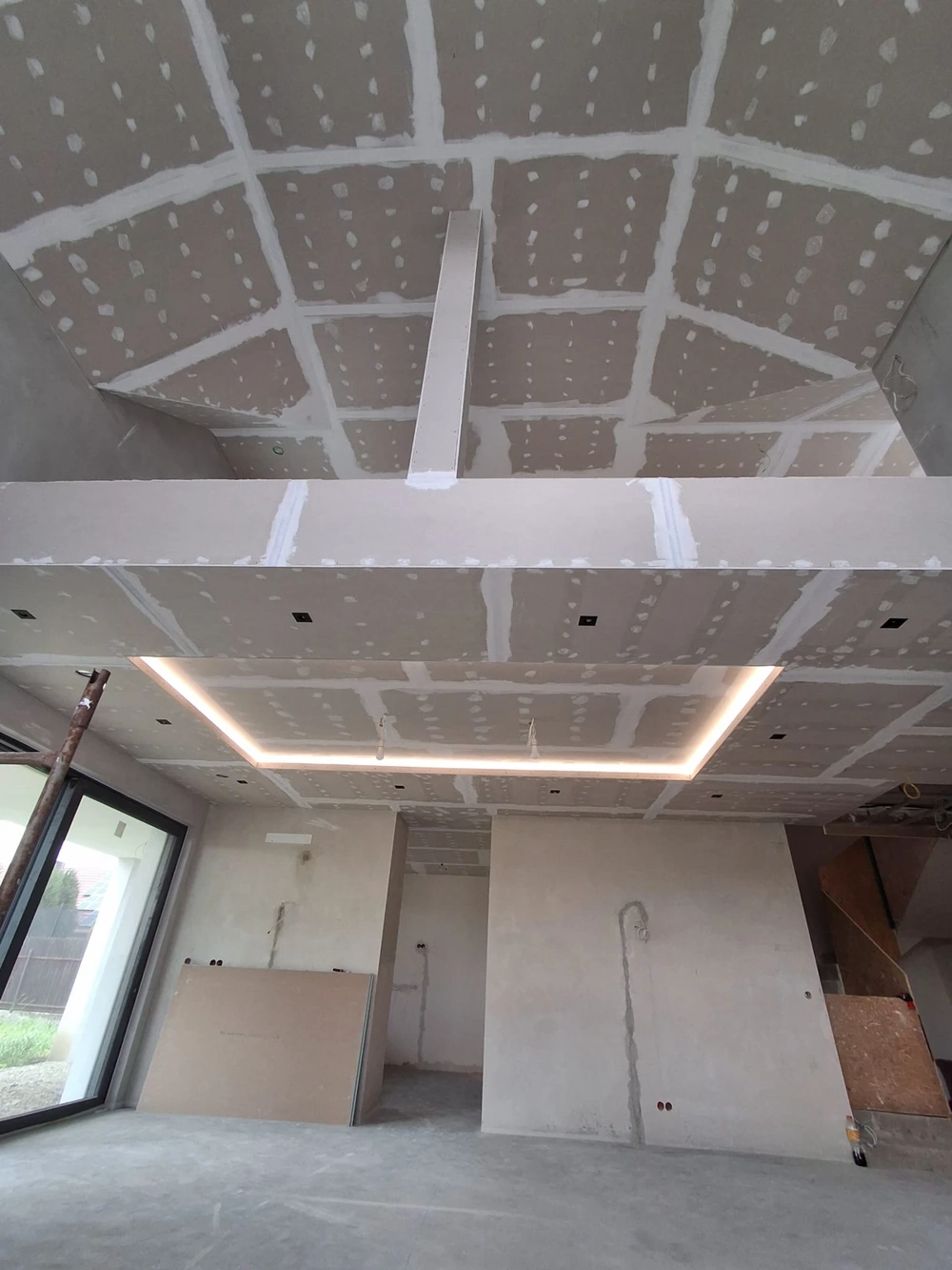 Wnętrze domu z zabudowanym sufitem karton-gips i przygotowanymi tynkami, gotowe pod malowanie – Stan deweloperski domu