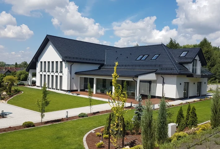 Nowoczesny dom jednorodzinny w stanie deweloperskim z elewacją i zagospodarowanym otoczeniem